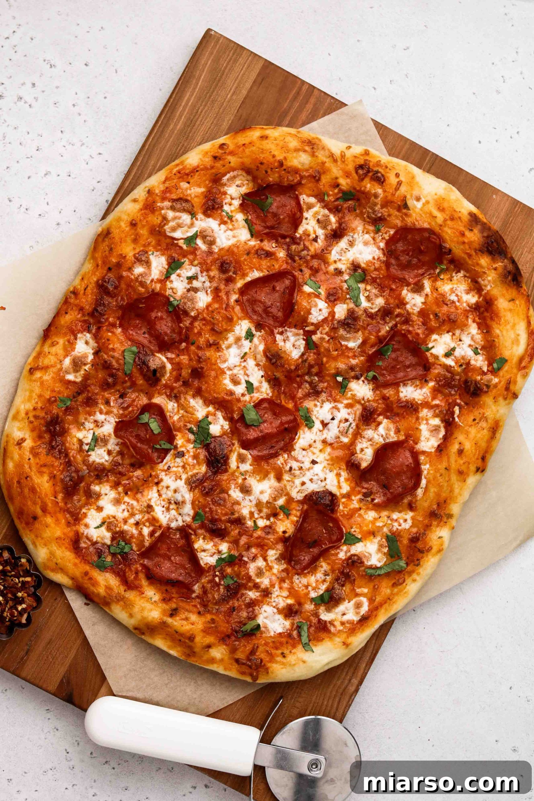 Overhead shot of a perfectly risen no-knead pizza dough, glistening with olive oil.