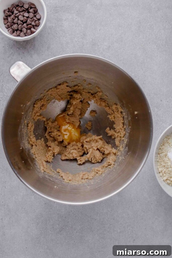 Creaming butter, sugar, and egg yolk in a mixer.