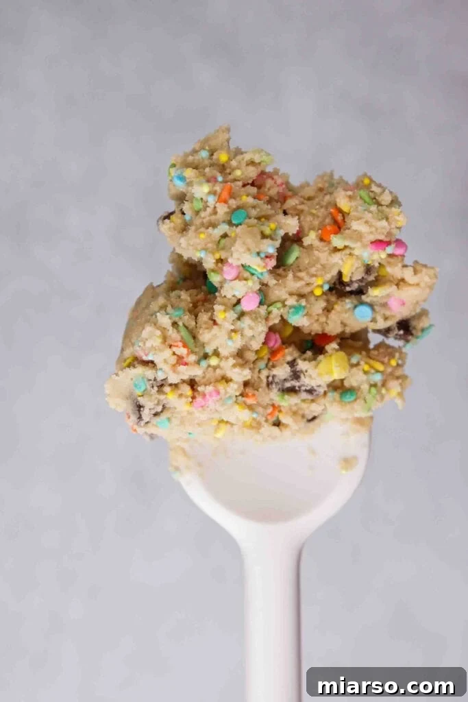 Close-up of colorful sprinkles being mixed into chocolate chip cookie dough