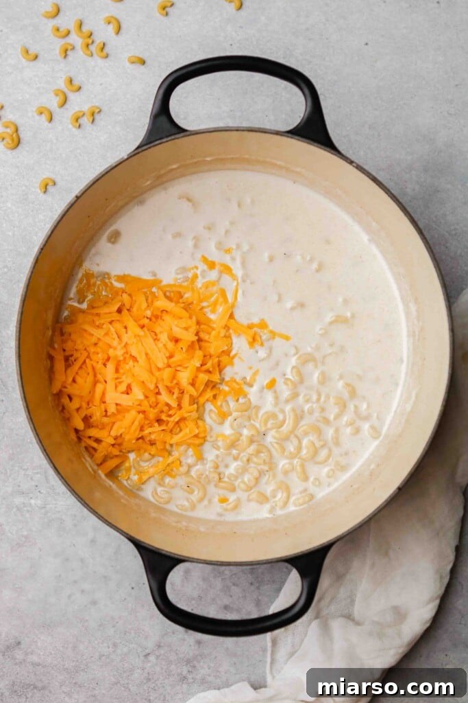 Overhead shot of stovetop mac and cheese pasta with shredded cheese