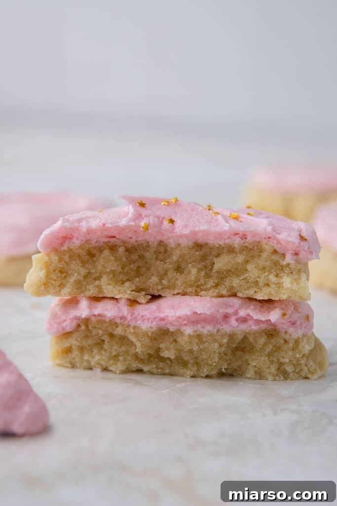 Close-up of a Crumbl sugar cookie broken in half, showing soft interior