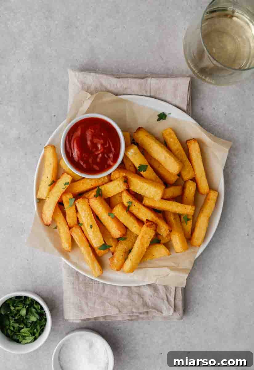 An overhead shot of air fryer polenta fries on a wooden board, showcasing their golden crispiness