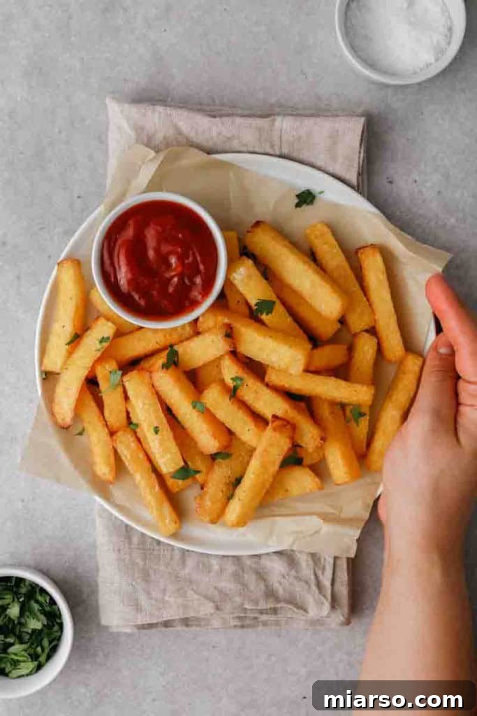 Air-fried polenta fries arranged neatly on a white plate, ready for serving