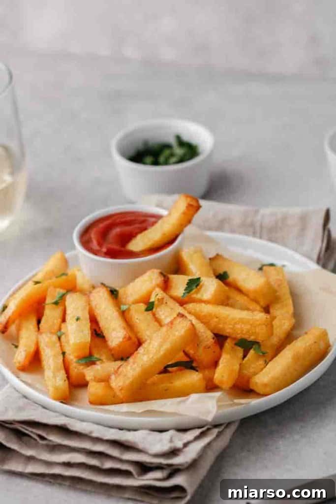 A plate of freshly air-fried polenta fries, golden and crispy, ready to be served as a healthy snack or side