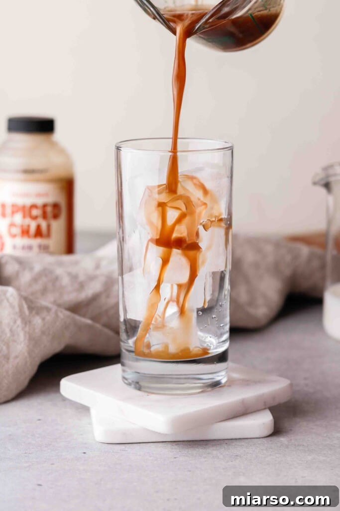 Adding chai concentrate to a glass with ice