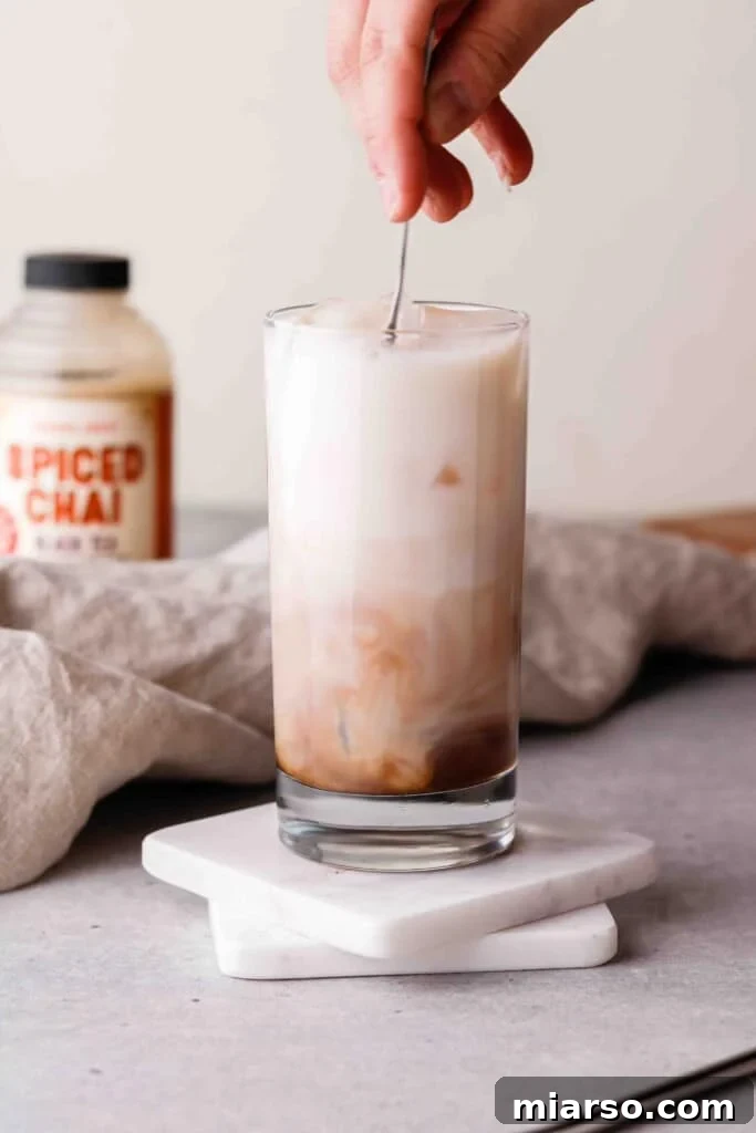 Stirring a homemade Starbucks iced chai tea latte