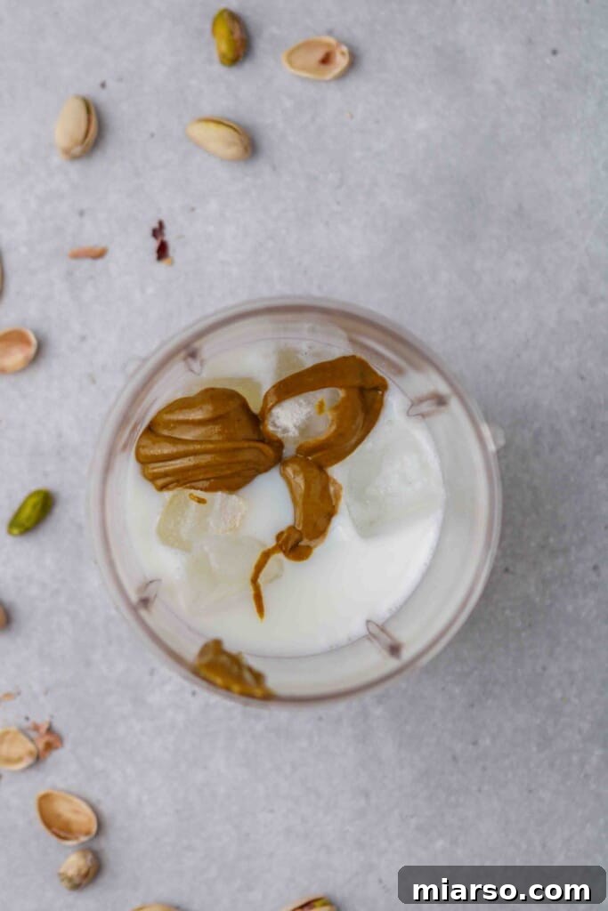 All the ingredients for the homemade pistachio frappe are carefully placed in a blender, ready for blending to create the copycat recipe.