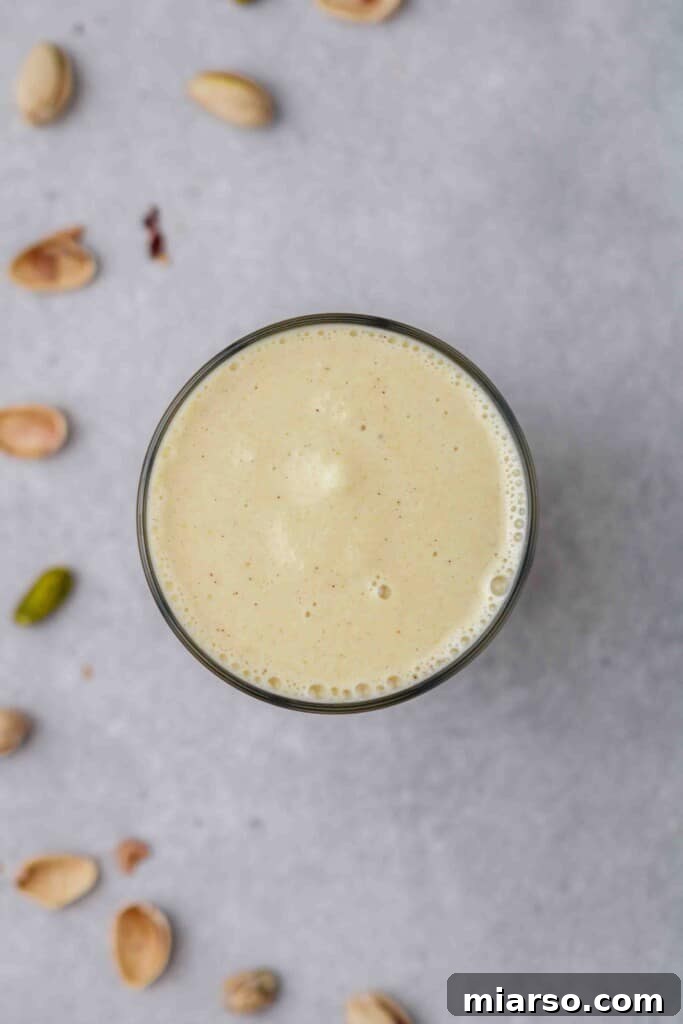 An overhead view captures the smooth, creamy texture of a perfectly blended homemade Pistachio frappuccino in the blender.