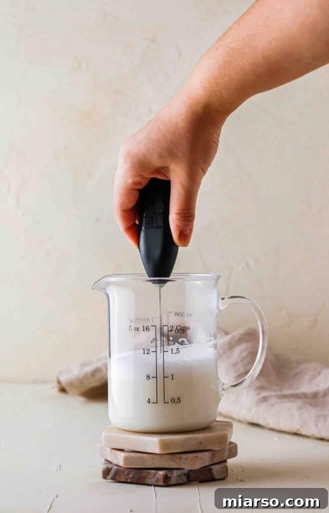 Handheld frother preparing milk