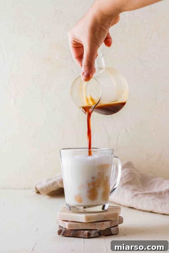 Pouring espresso into steamed milk