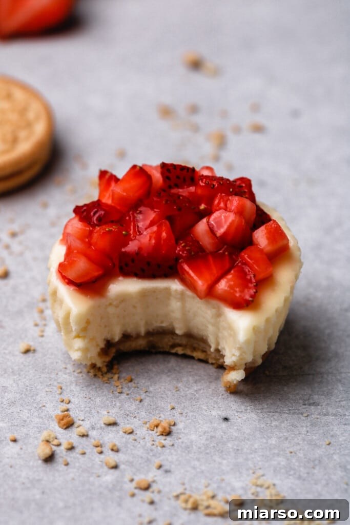Close up of a strawberry cheesecake with a bite taken out of it, showing texture