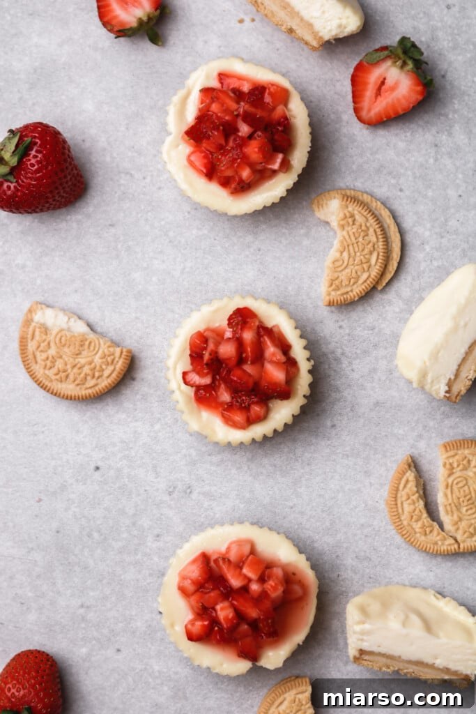 OVerhead shot of small batch mini cheesecakes with strawberry topping, beautifully arranged