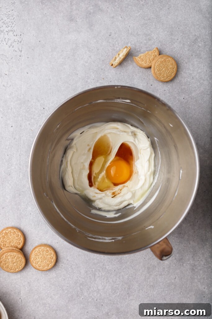 Adding egg and vanilla extract to cheesecake batter