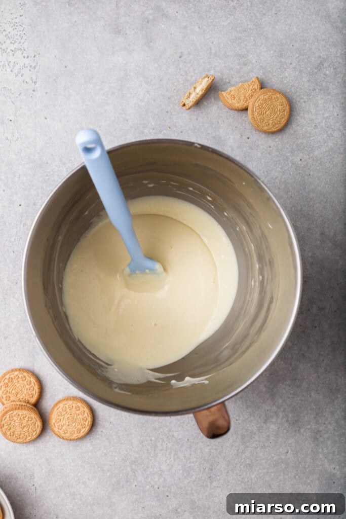 Mixing egg and vanilla into cheesecake batter until just combined