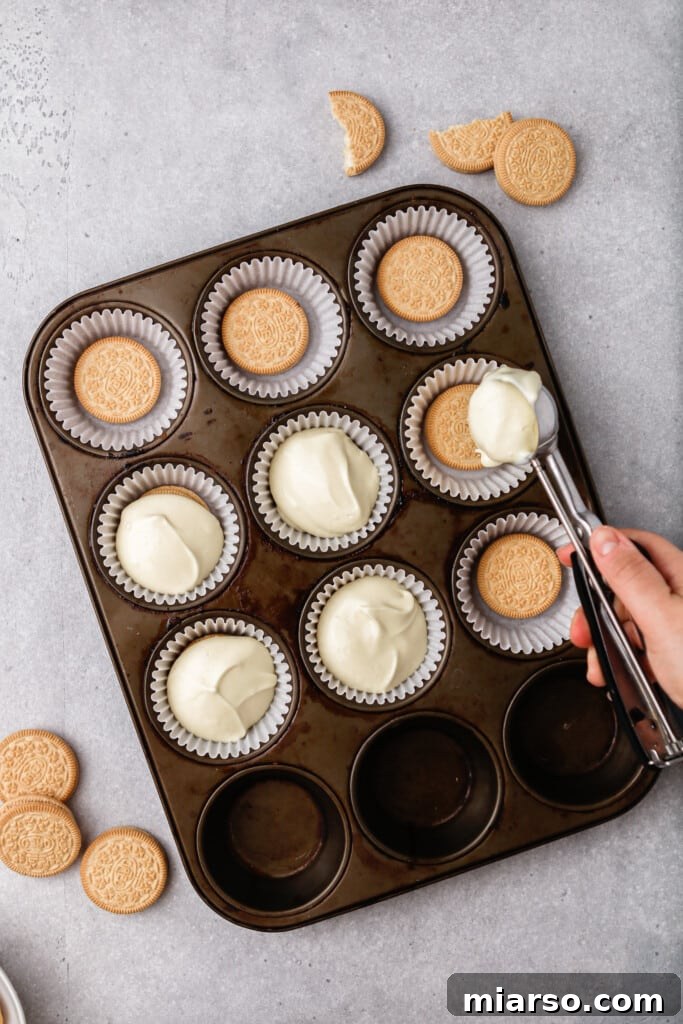 Pouring cheesecake batter into prepared muffin liners