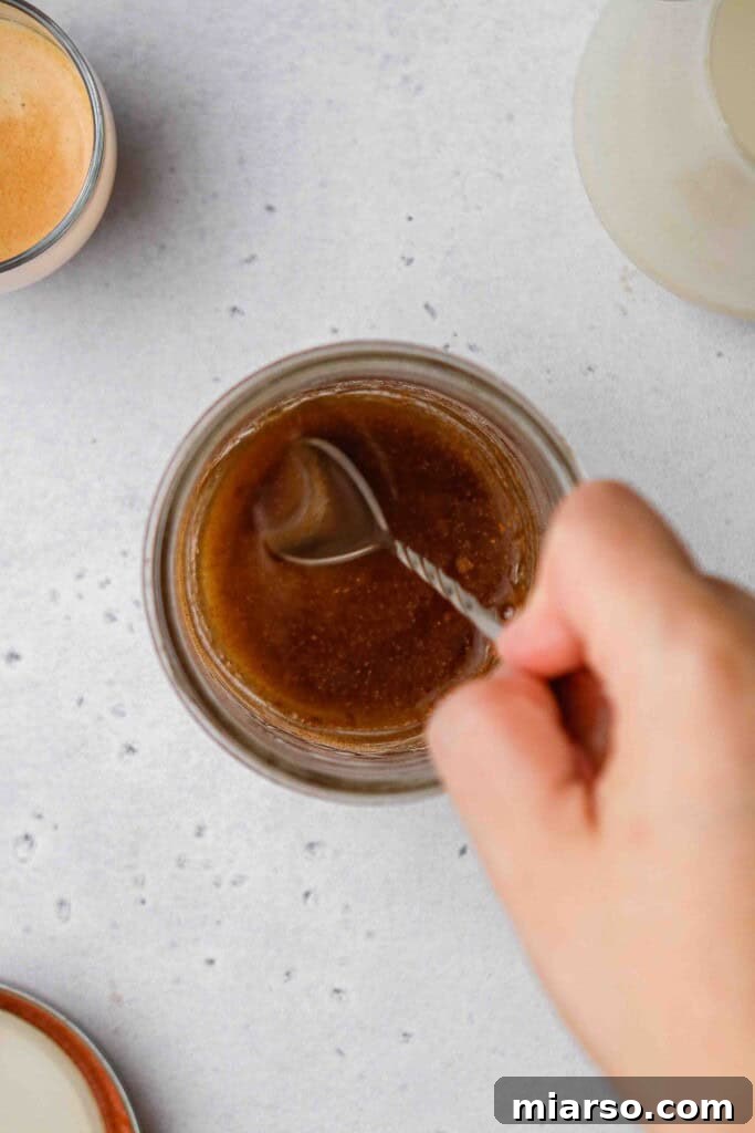 Golden Oat Shaken Espresso 7 Spoon stirring brown sugar syrup ingredients in a jar
