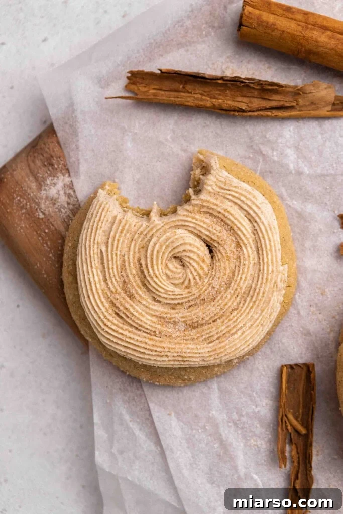 Overhead shot of a beautifully frosted homemade Crumbl Churro Cookie, ready to be enjoyed with a sprinkle of cinnamon sugar.