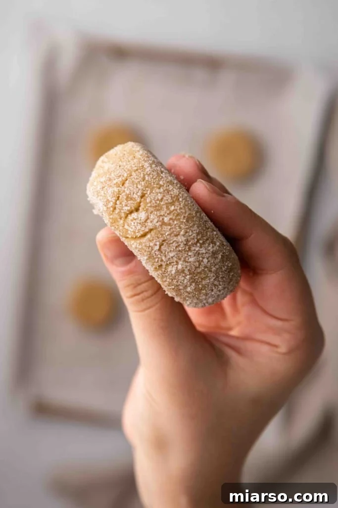 A hand demonstrating the ideal thickness of a churro cookie before baking, about 2cm.
