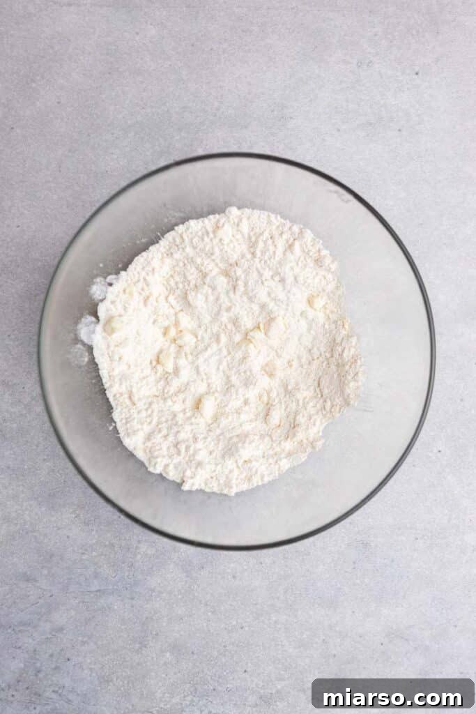 Flour and butter mixture in a bowl, showing pea-sized butter pieces after cutting.