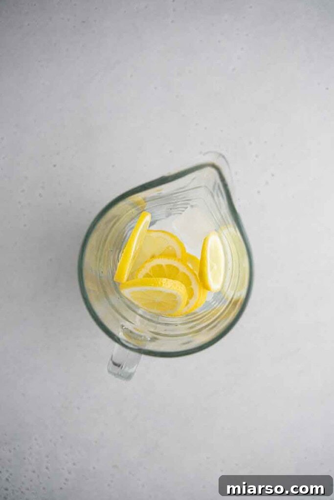 Lemon sliced and ice in pitcher for creamy lemonade