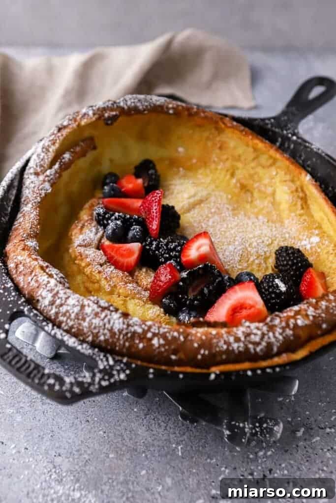 Dutch baby pancake in a skillet, freshly baked with puffed edges