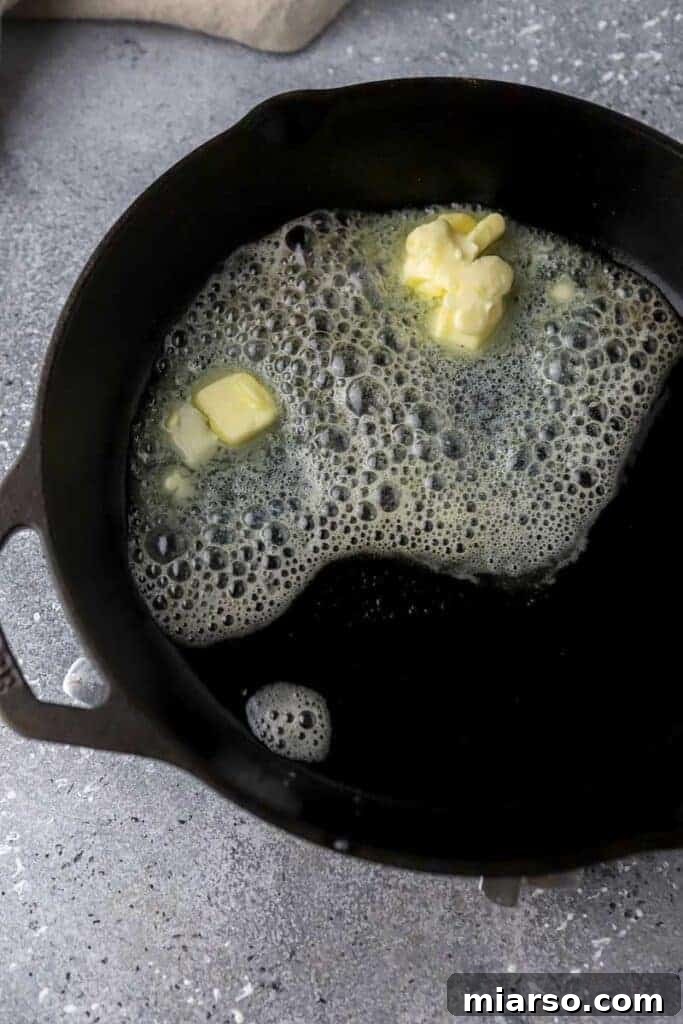 Melted butter sizzling in a hot cast iron skillet