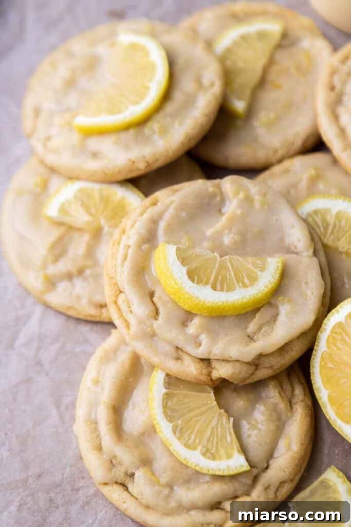 Effortless Crumbl Lemon Glazed Cookies 2 Lemon cookies cooling on a baking sheet, freshly baked and ready for glaze.