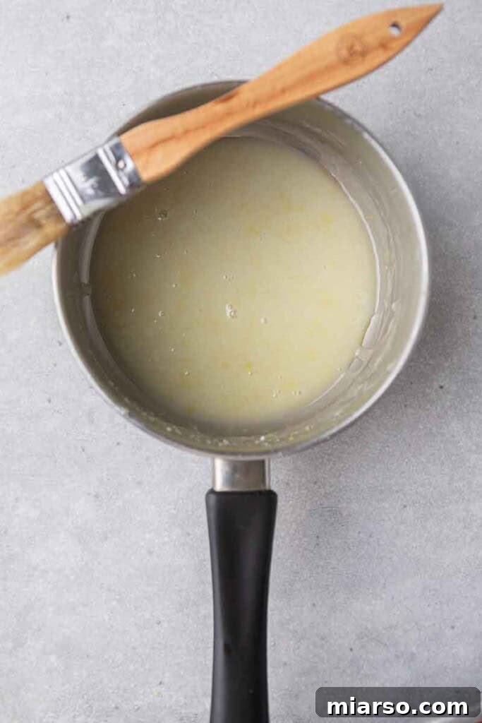 Effortless Crumbl Lemon Glazed Cookies 11 Smooth lemon butter glaze in a saucepan, ready for application.