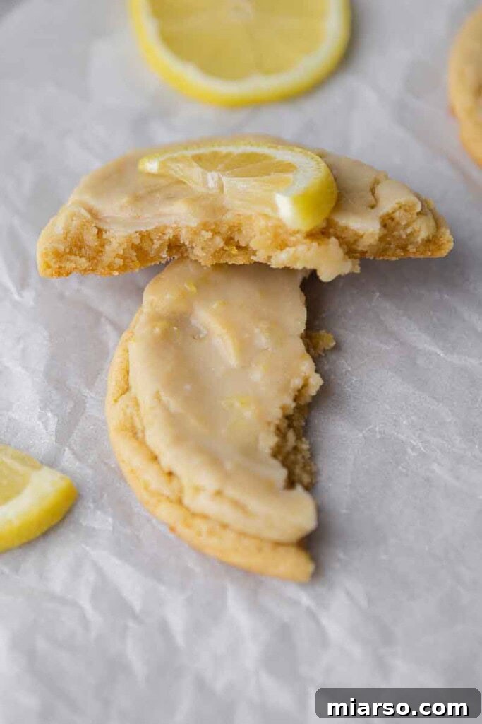 Effortless Crumbl Lemon Glazed Cookies 15 Close-up of the soft, chewy texture inside a sliced lemon cookie.