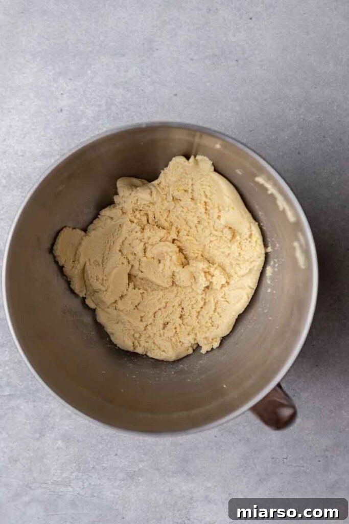 Effortless Crumbl Lemon Glazed Cookies 6 Cookie dough with lemon zest in a mixing bowl, ready to be scooped.