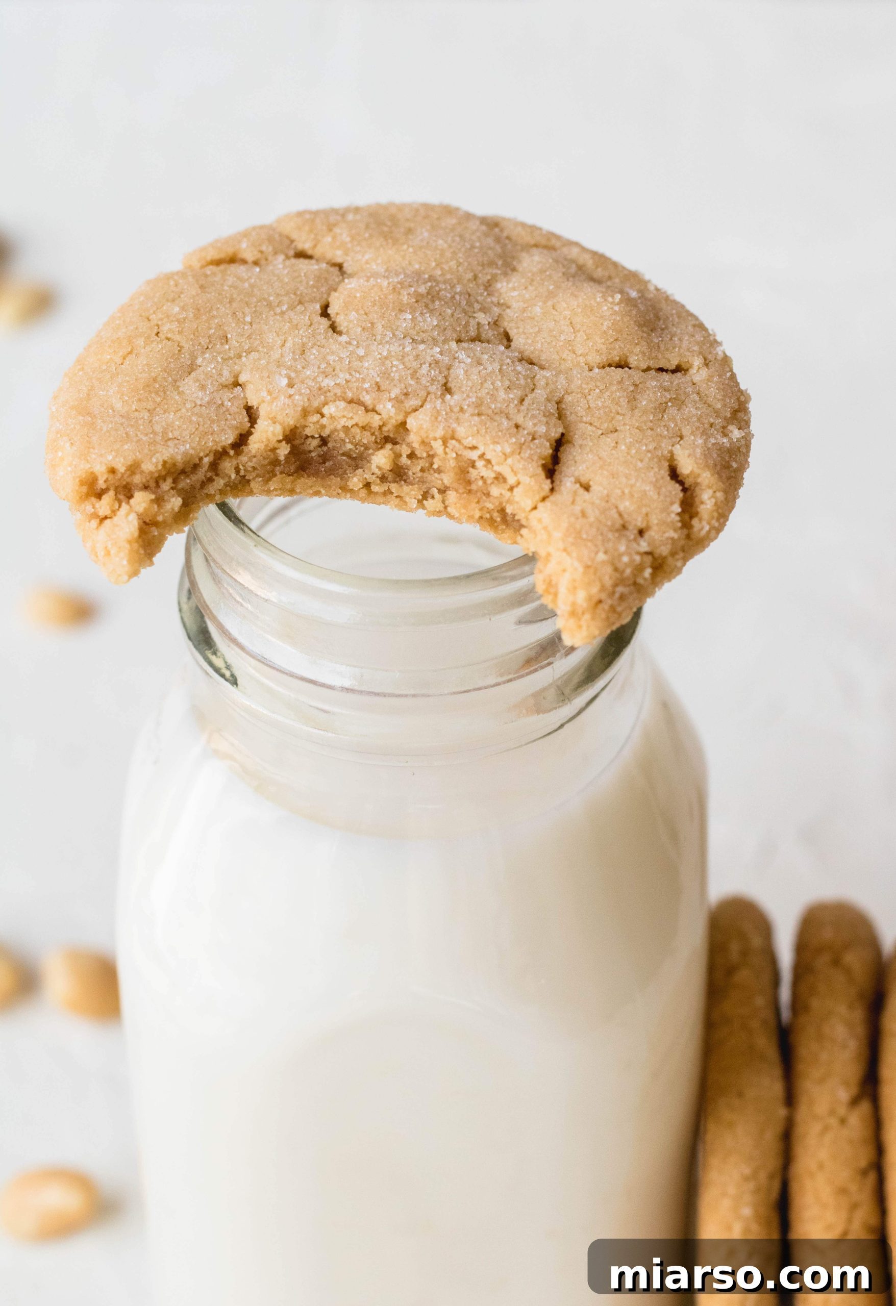 The best peanut butter cookie recipe - a stack of soft, chewy small batch peanut butter cookies with a bite taken out of one