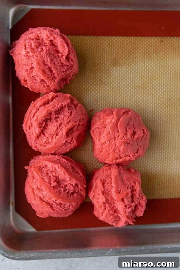 Pink cookie dough on baking sheet