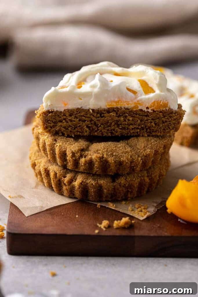 Delicious CRUMBL Peaches and Cream Cookies on a cooling rack, showcasing the perfect golden-brown graham cracker base and creamy peach topping.