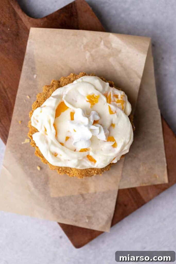 A finished Crumbl peaches and cream cookie in a tart pan, topped with the luscious cream and peaches, ready to be enjoyed.