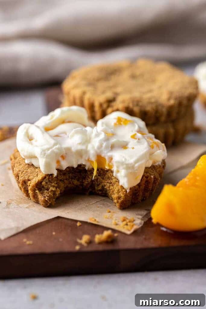 Close-up of a peaches and cream cookie with a bite taken out, revealing the soft interior and creamy filling, enticing the viewer.