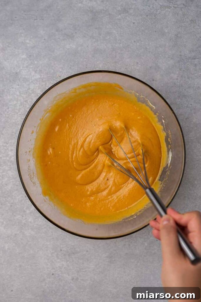 Wet ingredients in a bowl for pumpkin bread batter