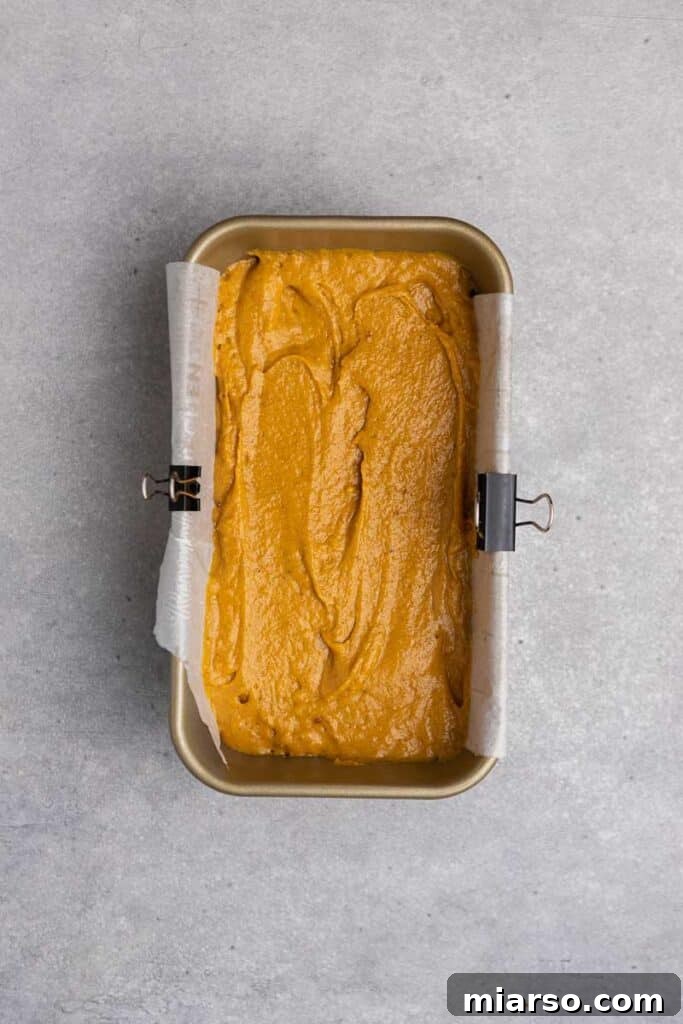 Pumpkin batter poured into a loaf pan