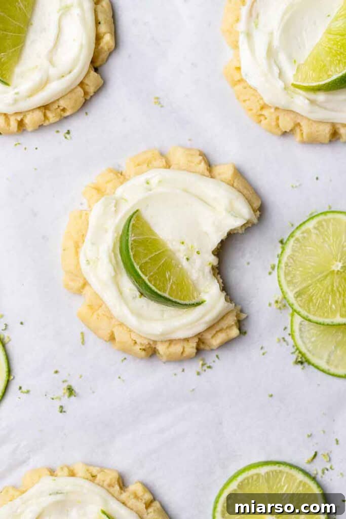 Close-up of a frosted coconut lime cookie with a lime wedge garnish