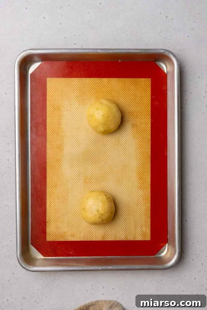 Cookie dough balls neatly arranged on a baking sheet
