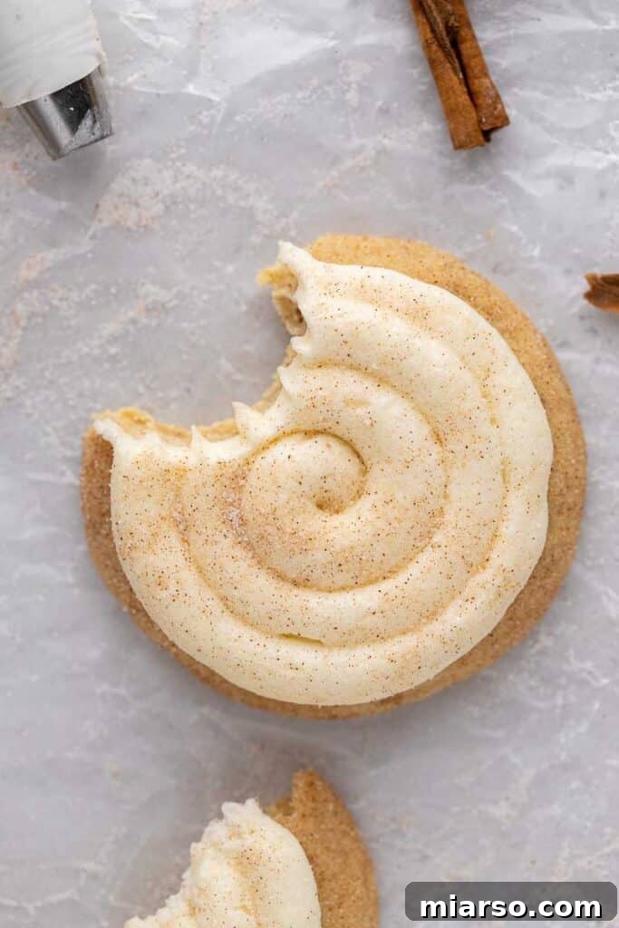 Overhead shot of a CRUMBL Snickerdoodle Cupcake Cookie with a bite taken out, showing the soft interior and frosting.
