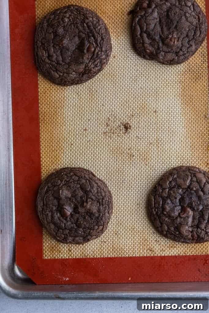 Crumbl's Rich Brownie Batter Indulgence 12 Freshly baked Crumbl brownie batter cookies cooling on a baking sheet