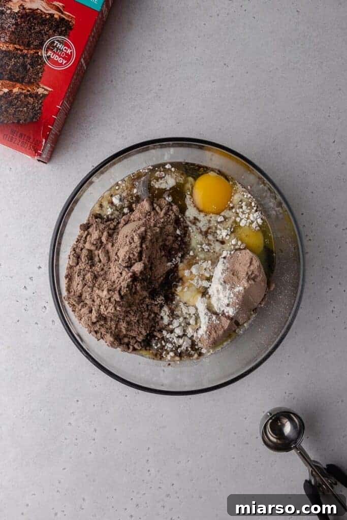 Crumbl's Rich Brownie Batter Indulgence 6 Dry ingredients and wet ingredients combined in a mixing bowl for brownie batter cookies