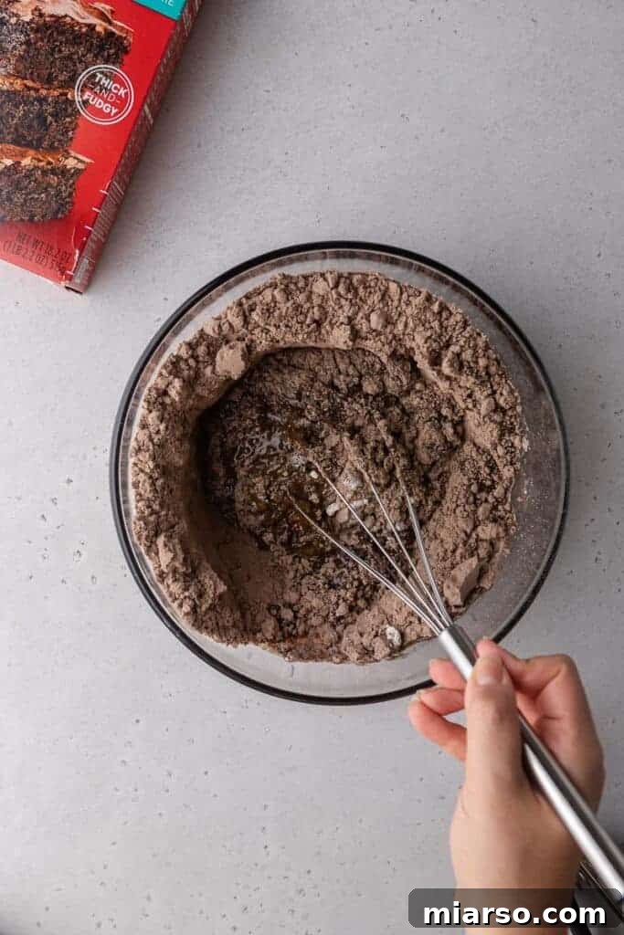 Crumbl's Rich Brownie Batter Indulgence 7 Hand mixing brownie batter cookie dough in a bowl