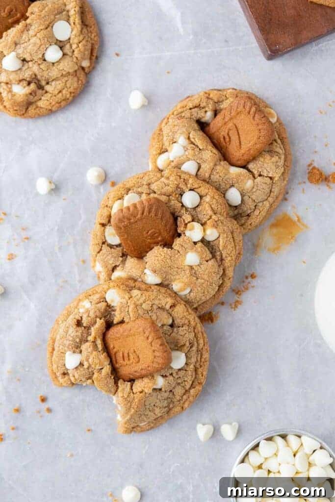The Best Crumbl Biscoff White Chip Cookies Recipe 12 Overhead shot of freshly baked cookie butter cookies, arranged invitingly on a cooling rack.