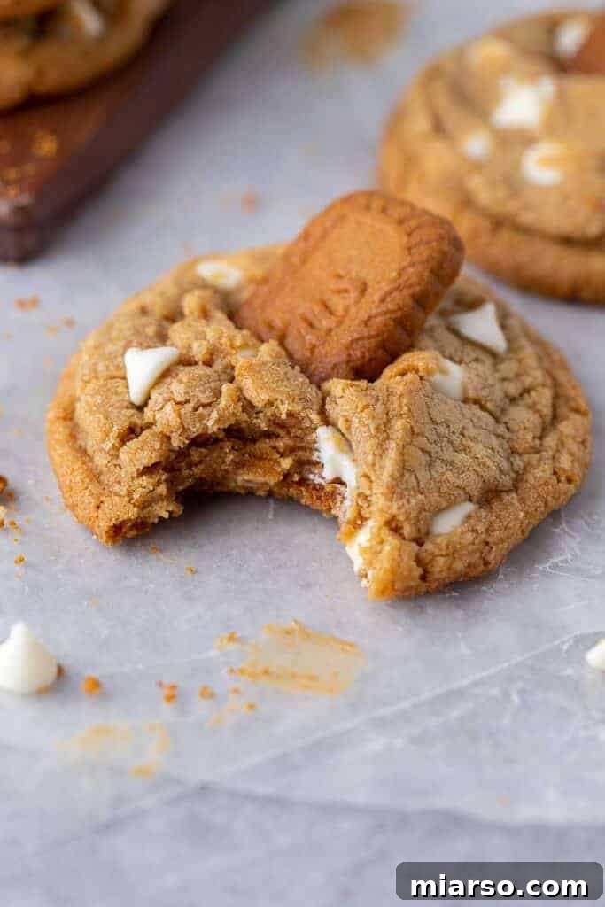 The Best Crumbl Biscoff White Chip Cookies Recipe 3 Close-up of a stack of Crumbl Biscoff white chip cookies, showing their thick, chewy texture and visible white chocolate chips