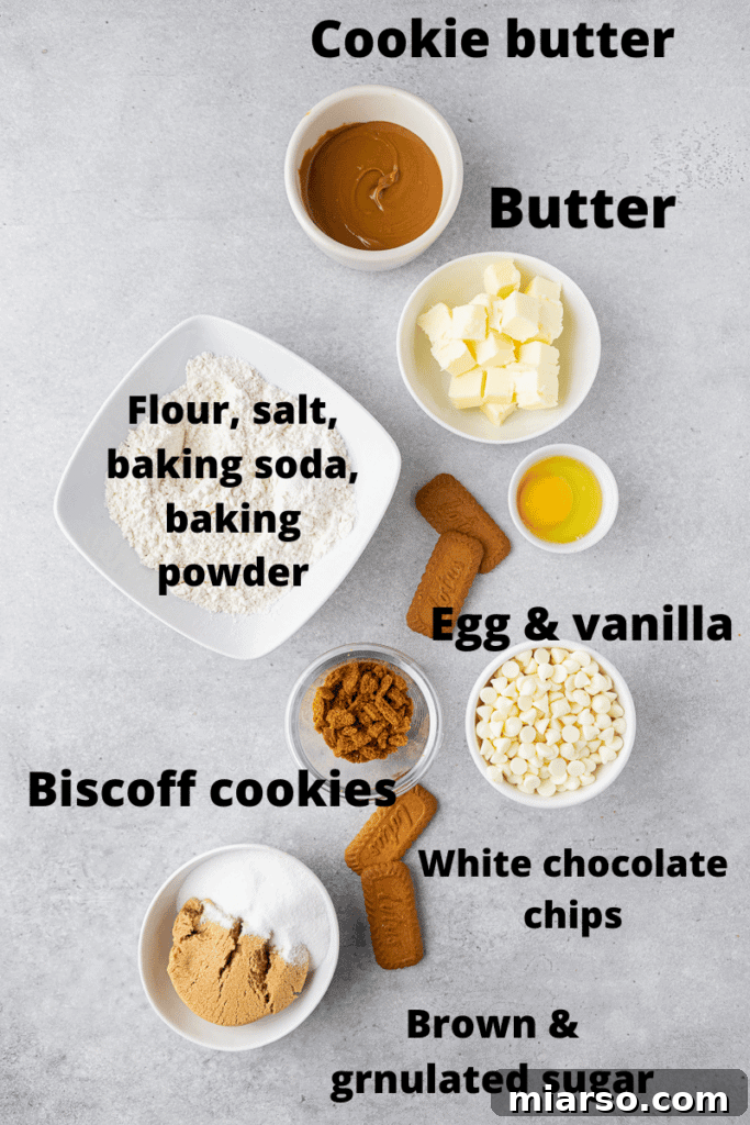 The Best Crumbl Biscoff White Chip Cookies Recipe 4 Various ingredients for Crumbl Biscoff white chip cookies laid out, including butter, cookie butter, sugars, eggs, flour, and white chocolate chips