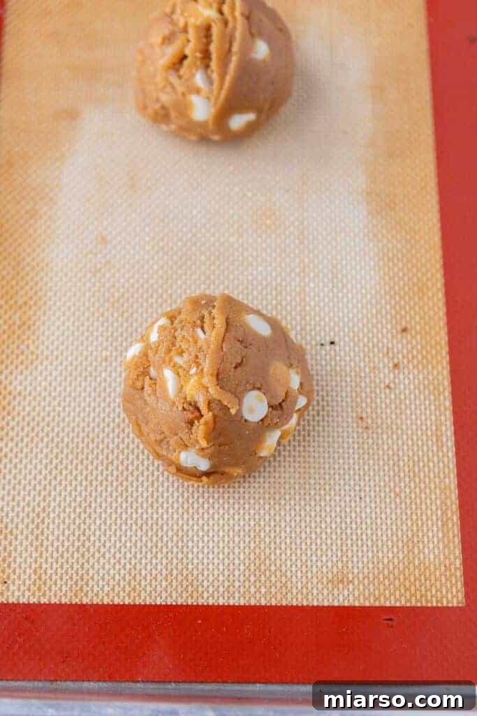 The Best Crumbl Biscoff White Chip Cookies Recipe 10 A perfectly scooped Biscoff cookie dough ball, ready for chilling and baking into a thick, delicious cookie.