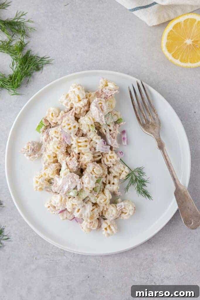 Flavorful tuna pasta salad served on a plate, garnished with fresh herbs