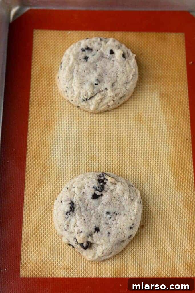 Freshly baked Oreo cookies on a parchment-lined baking sheet