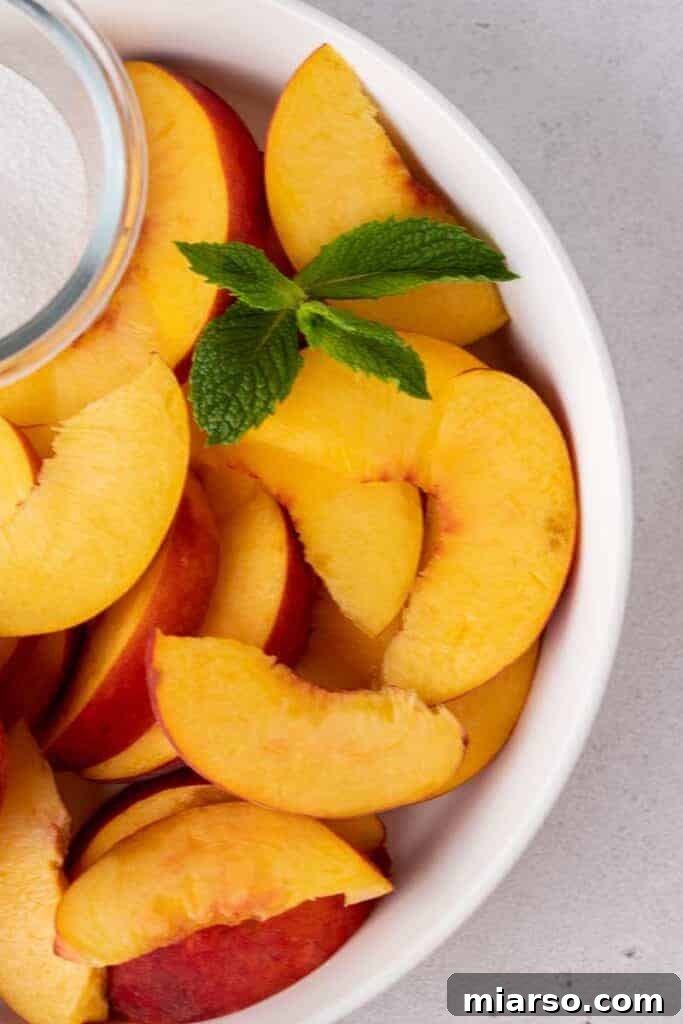 Perfectly sliced ripe peaches arranged on a plate, ready to be used in peach iced tea or as a garnish.